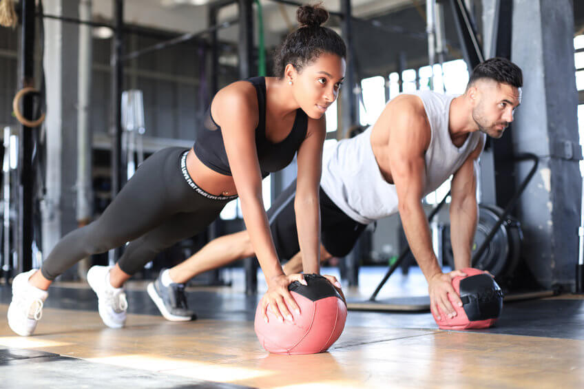 Young couple doing core exercises with fitness balls