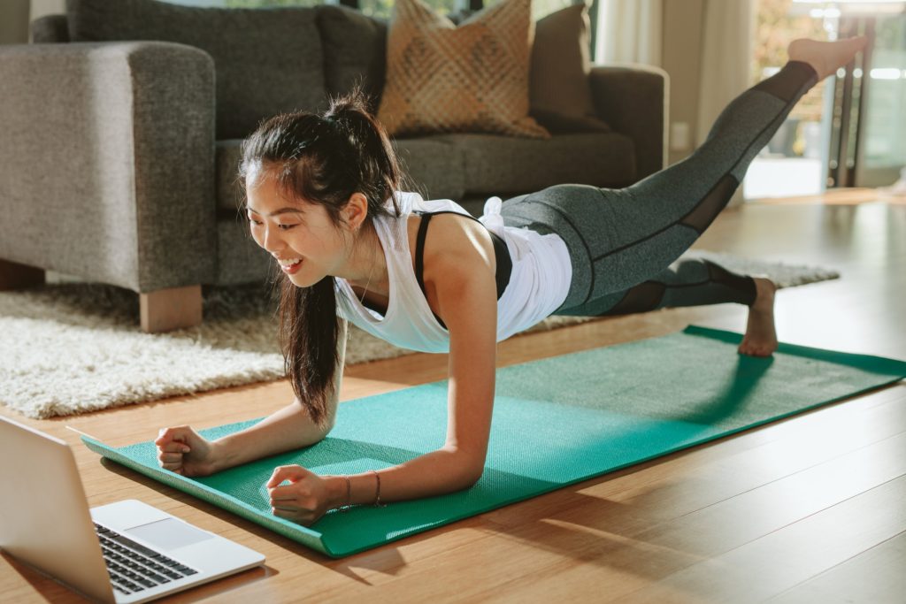 woman in a plank position doing a full-body workout at home
